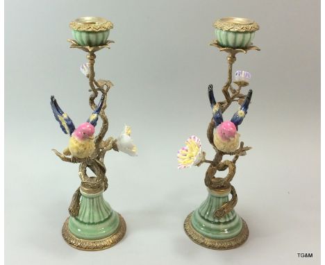 A pair of ceramic very ornate ormolu candlestick depicting tropical birds