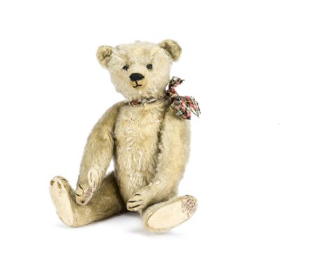 A Steiff teddy bear circa 1910, with blonde mohair, black boot button eyes, pronounced muzzle, black stitched nose, mouth and