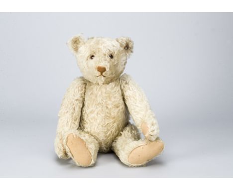 A fine1920s white mohair Steiff teddy bear, With clear and black glass eyes with brown backs, pronounced muzzle, brown stitch