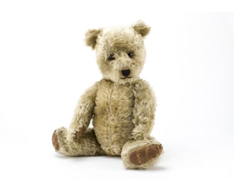 A post-war Chiltern Hugmee teddy bear, With blonde mohair, orange and black glass eyes, black stitched nose, mouth and claws,