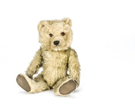 A Chiltern Ting-a-Ling teddy bear 1950s, With blonde mohair, orange and black glass eyes, inset short mohair muzzle and tops 