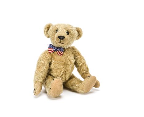 An Ideal teddy bear circa 1910,  With golden mohair, black boot button eyes, pronounced muzzle, black stitched nose, mouth an