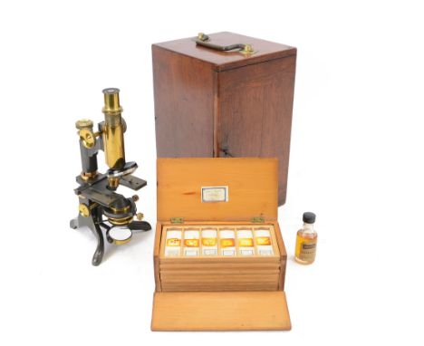 Early 20th century brass microscope, with black lacquer finish by C. E Baker of High Holborn, with lenses and plates containe