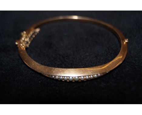 9ct gold bangle set with seed pearls with safety chain Weight 8.4g