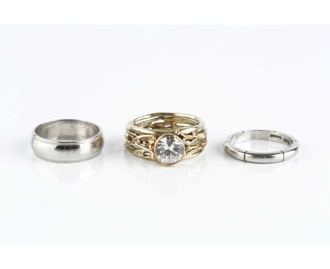 Two 9ct white gold wedding bands, the first with linear decoration, the second with millegrain borders, and a white stone dre