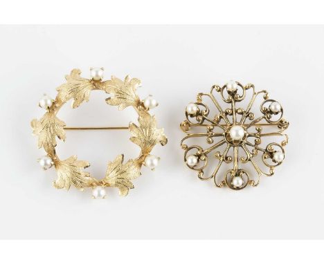 Two cultured pearl panel brooches, the first designed as a foliate wreath of textured design, stamped '14K', the second desig