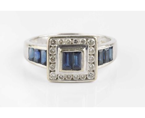 A sapphire and diamond cluster ring, centred with a pair of rectangular step-cut sapphires, bordered by round brilliant-cut d