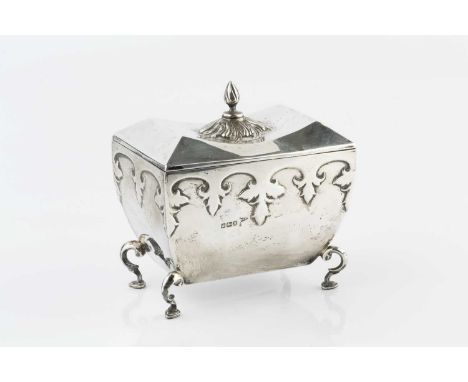 A silver tea caddy, of shaped rectangular form, the body with stylized relief foliate decoration, on scrolling legs with pad 