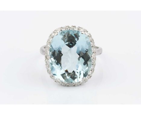 An aquamarine and diamond cluster ring, the cushion-shaped mixed-cut aquamarine claw set within a border of single-cut diamon