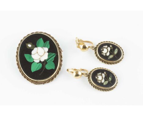 A pietra dura panel brooch, the oval pietra dura panel depicting a floral spray in shades of white, green and black, within a