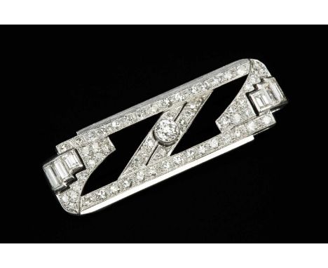 An Art Deco diamond panel brooch, the shaped rectangular panel of stepped design, centred with a round brilliant-cut diamond 