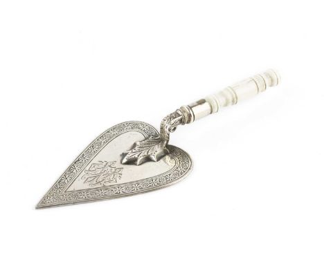 A mid Victorian silver miniature trowel, the heart shaped blade engraved with a border of stylised flowerheads, and having tu