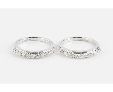 A pair of diamond half hoop rings, each with a line of slightly graduated round brilliant-cut diamonds in claw settings, 18ct