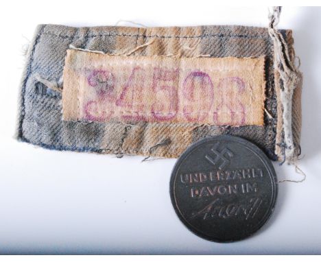 A piece of cloth in the blue and white stripes on a concentration camp uniform with stitched cotton patch stencilled 34598, 4