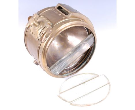 An early 20th century brass cased ships search light, having a 10 inch circular lens cover with four glass panels, with furth