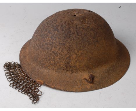 A British Brodie pattern helmet, with remains of chainmail guard.