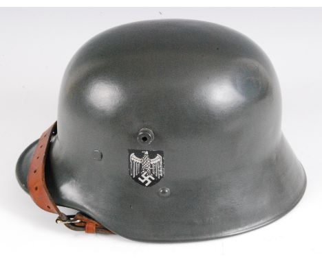 A German M1916 pattern steel helmet with WW II army double decals, having a leather liner and chin strap, stamped to the inte