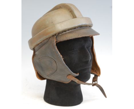 A German Air Service flying helmet, having a green leather covered skull with short brown leather front peak, ear and neck fl