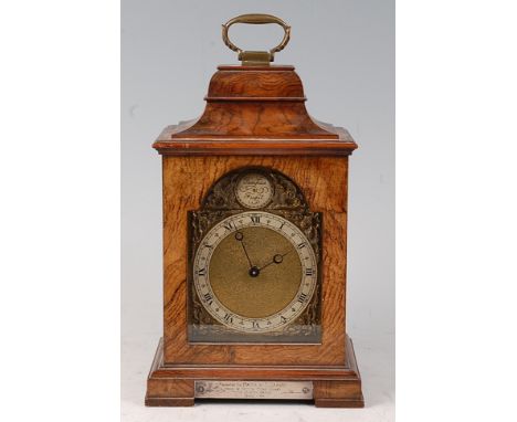 A mid-20th century walnut cased mantel clock, having an arched brass dial with Roman numerals and Swiss cylinder movement, be