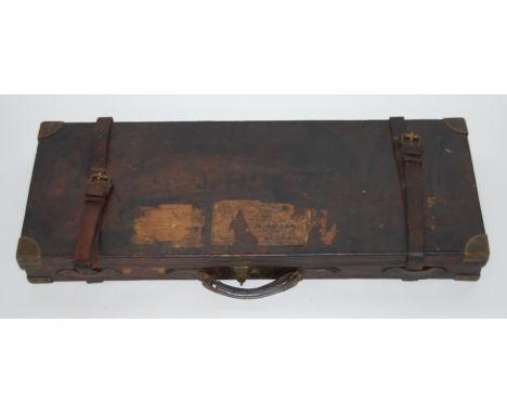 An early 20th century oak, brown leather and brass bound shotgun case, having a red felt lined fitted interior to take two gu