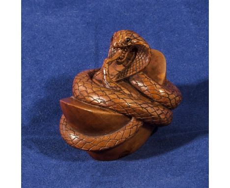 A carved wooden netsuke of a snake, signed