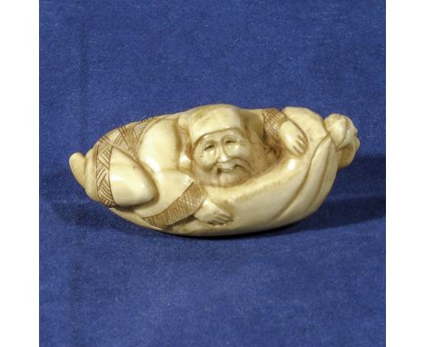 An ivory netsuke, man in a hammock, signed