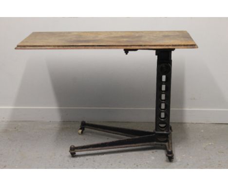 EARLY 20TH CENTURY CAST IRON ADJUSTABLE BED TABLE raised on adjustable four branch base and ceramic casters bearing label Win