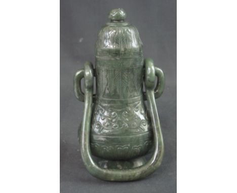 CHINESE CARVED SPINACH JADE LIDDED BALUSTER SHAPED URN with overall leaf and scroll decoration and having loop swing handle. 