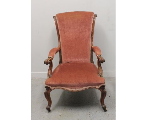 EARLY VICTORIAN MAHOGANY SCROLL BACKED FIRESIDE ELBOW CHAIR, having padded scrolled arms, stuff over serpentine seat on cabri