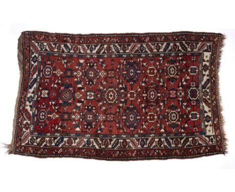 Caucasian red ground rug with foliate medallions and foliate and geometric multiple border, 124cm x 212cm Condition: some los
