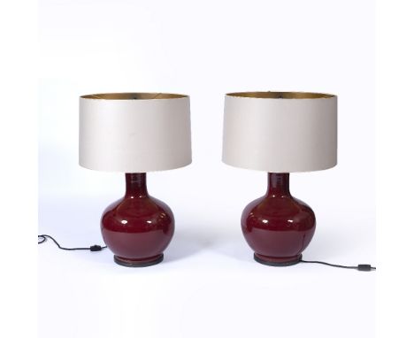 Pair of ox-blood bottle vase lamps in the Chinese style, each with a metal base and shade, 82cm high overall, height of vase 