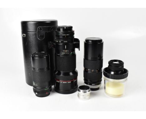 A collection of camera lenses comprising a Canon FD 300mm 1:4 L, a Canon FD 200mm 1:4 lens, a Canon FD 80-200mm 1:4 zoom lens