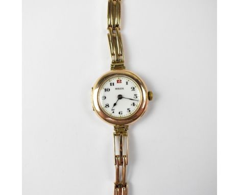 ROLEX; a vintage 1914 ladies' pink/rose gold wristwatch, the white enamelled dial set with red number 12 and black Arabic num