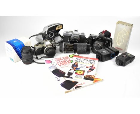 A collection of cameras and camera equipment to include a Minolta SRT 201, an Olympus OM10, a Canon EOS 500 and a Polaroid P 