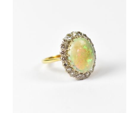 An 18ct yellow gold ring set with central opal surrounded by twenty diamonds, size P 1/2, approx 7.6g. CONDITION REPORT Scrat