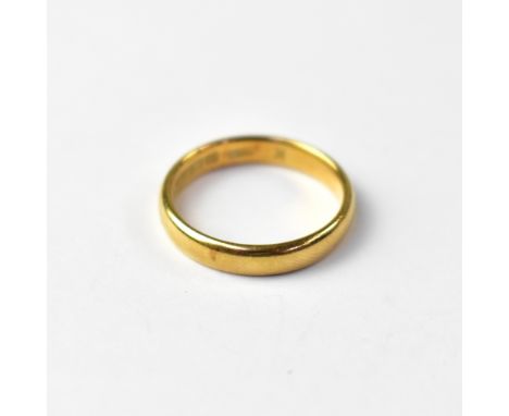An 18ct gold band ring, size K, approx 3.2g.