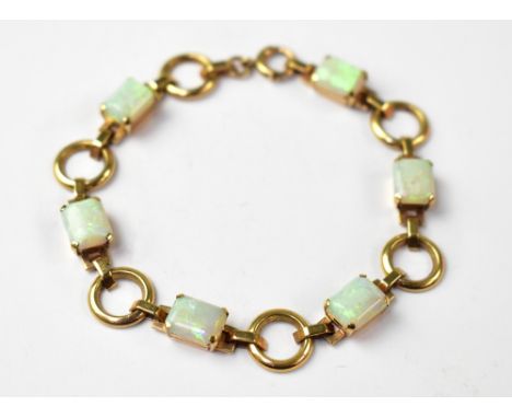 A modern 9ct gold and opal bracelet, the six rectangular white opal panels with hints of green and faint blue, in claw set sq