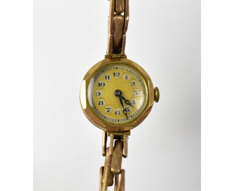A vintage 9ct gold ladies' wristwatch, the gold engine turned dial set with Arabic numerals in silver coloured circles, crown