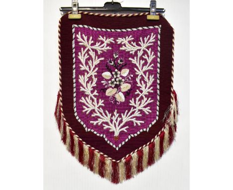 A Victorian beadwork in the form of a shield with tassels and fringes, central purple panel with bugle and other beads, flora