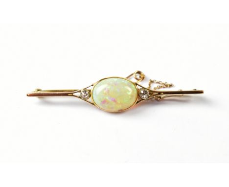 A yellow metal bar brooch set with central opal flanked by two diamonds, with safety chain.