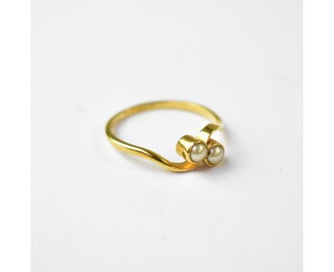 An 18ct gold pearl cross-over ring, with two small bezel set pearls in a cross-over mount, on an 18ct yellow gold shank, size