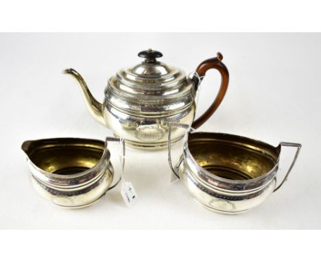 A George III hallmarked silver three-piece tea service, comprising teapot, height 17.5cm, sucrier and milk jug, with chased b