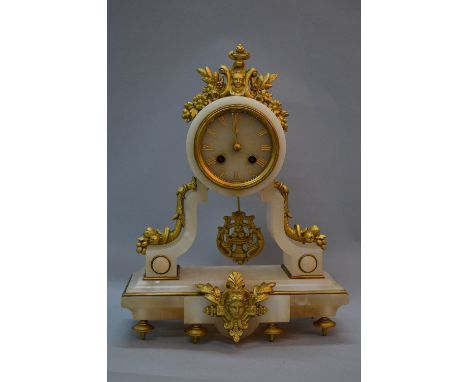 A LATE 19TH CENTURY FRENCH EIGHT DAY ALABASTER MANTEL CLOCK, the drum head with gilt metal mask and swag surmount, gilt Roman