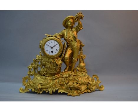 A LATE 19TH CENTURY FRENCH GILT METAL THIRTY HOUR MANTEL CLOCK, cast with a boy holding grapes aloft with sickle in his other