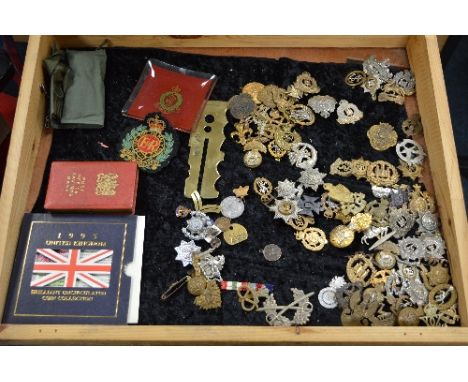 A LARGE GLAZED DESKTOP DEALERS/TRADERS DISPLAY CASE, containing a large number of WWII era military cap badges, mostly Britis