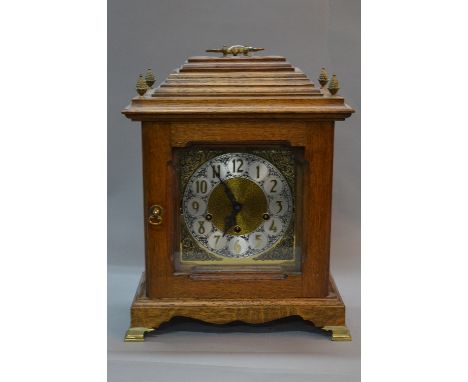 A MID 20TH CENTURY GERMAN OAK CASE BRACKET CLOCK, stepped caddy top with carrying handle, pineapple finials, brass dial and s