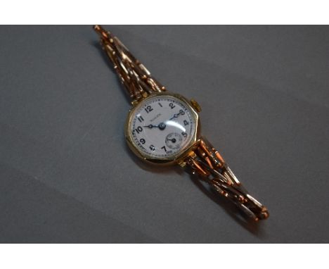 AN EARLY 20TH CENTURY LADIES ROLEX 9CT GOLD WRISTWATCH, white enamel dial, signed Rolex, Arabic numerals, blue steeled hands 