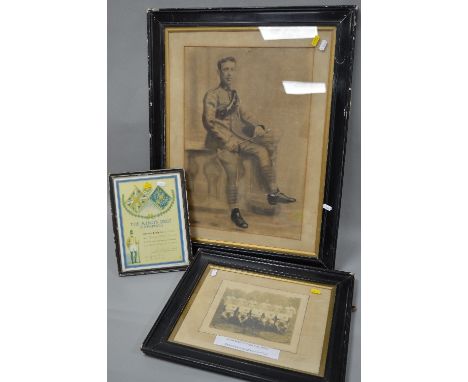 A LARGE WOODEN AND GLAZED FRAME CONTAINING A PENCIL/CHARCOAL DRAWING OF A POSED BRITISH SOLDIER SITTING WITH AMMUNITION BELT 