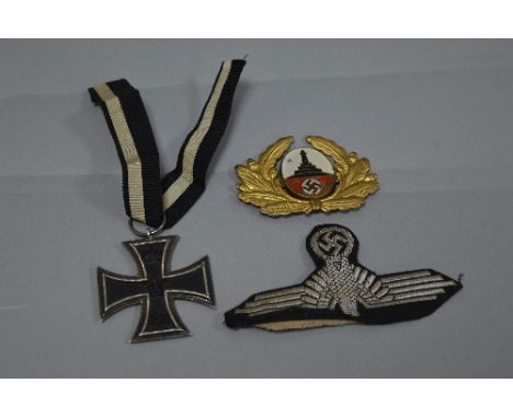 A WWI IMPERIAL GERMANY IRON CROSS WITH RIBBON, believed one piece construction, also a WWII Eagle and Swastika patch in black