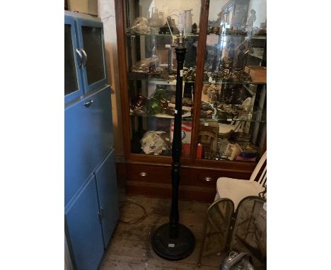 An ebonised standard lamp, with shade, height excluding fitting 145cm.